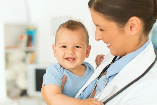 lekarka trzyma dziecko na rękach